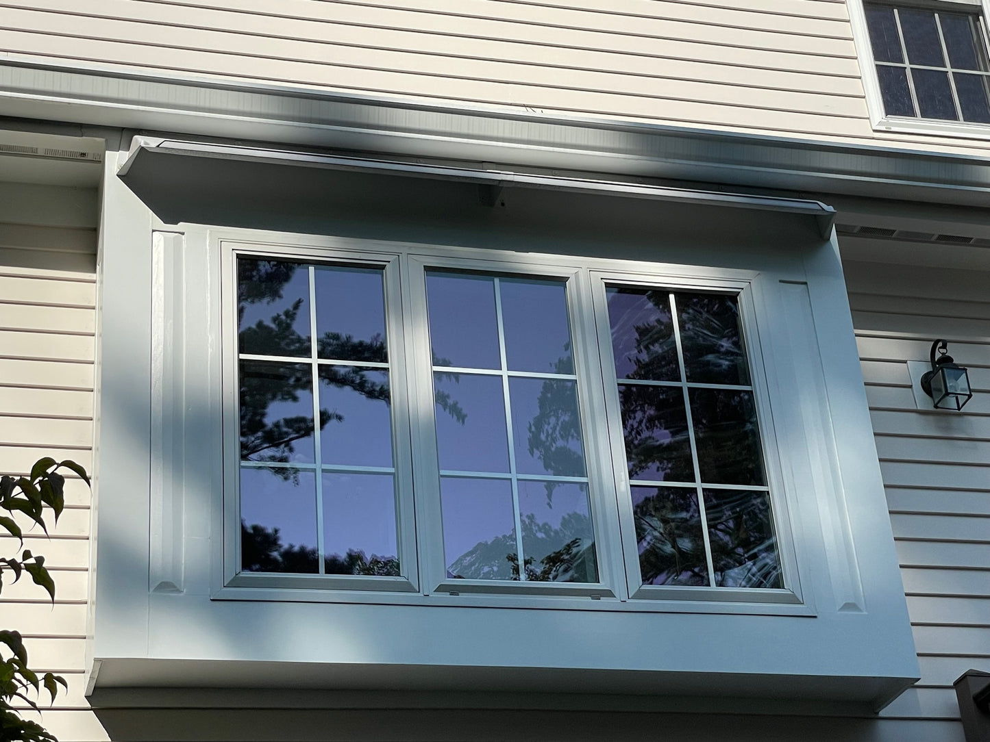 Rain guards for house above large triple pane bay window.