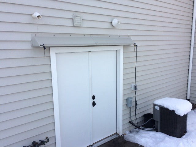 Rain diverter installed above double French door on house exterior preventing leaks