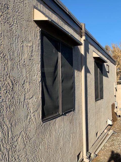 Beige rain diverter mounted above a horizontal sliding window.