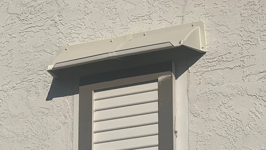 DOORBRIM gable vent hood or canopy mounted above louvered vent.
