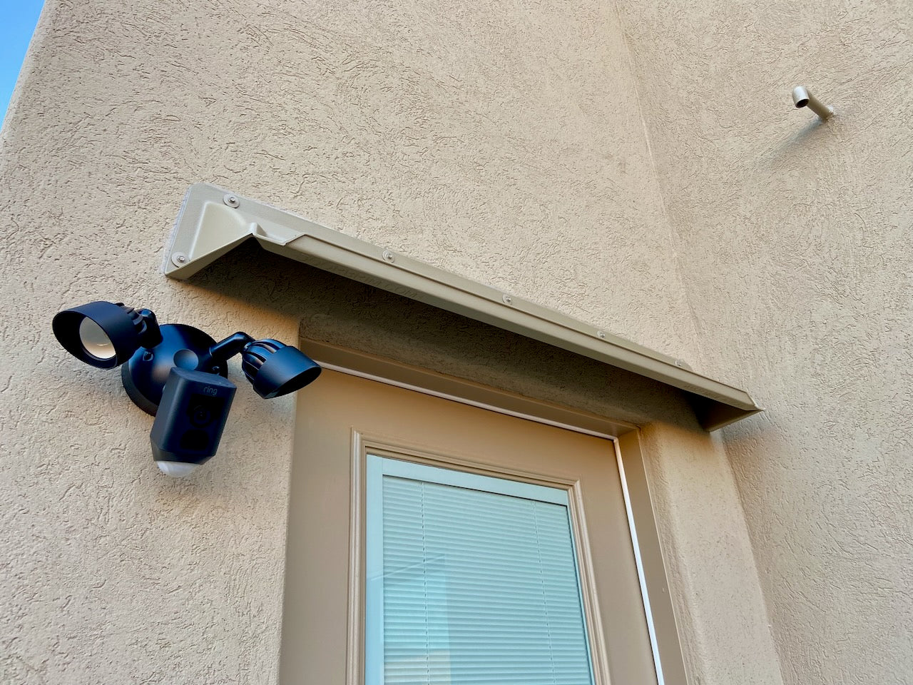 Overhead door rain guard made of durable ABS plastic protecting a house door from leaks and drips, standard width 52 inch