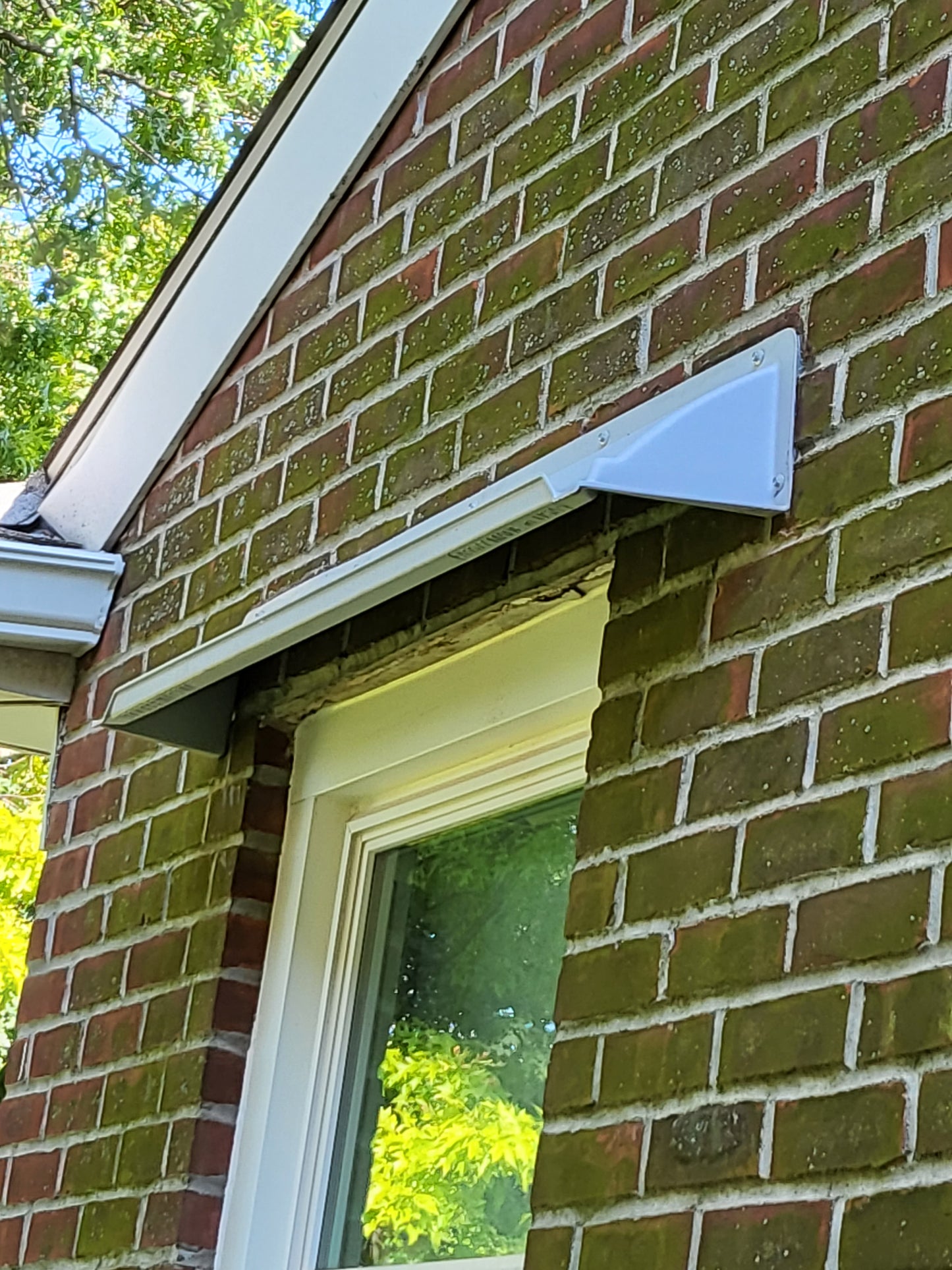 Rain guards for house mounted on brick.