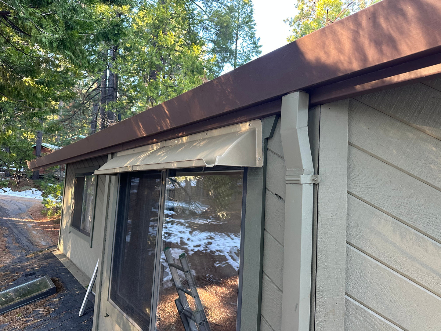 Extended width rain drip guard installed above a window to prevent leaks, made from durable ABS plastic in light beige, designed for houses.