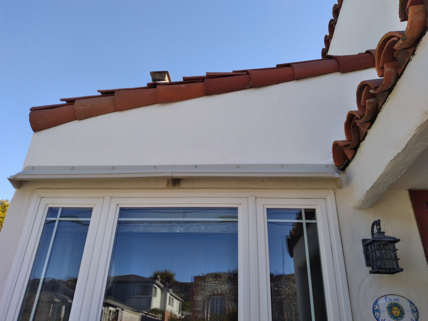 Rain guards for house installed over large bay window with two side lights.