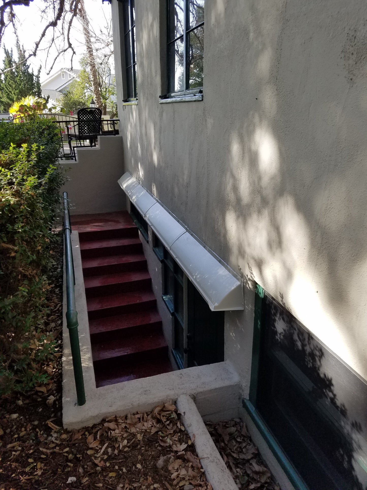 fix leaking windows during heavy rain with a DOORBRIM rain diverter shown above a long stairwell window. 