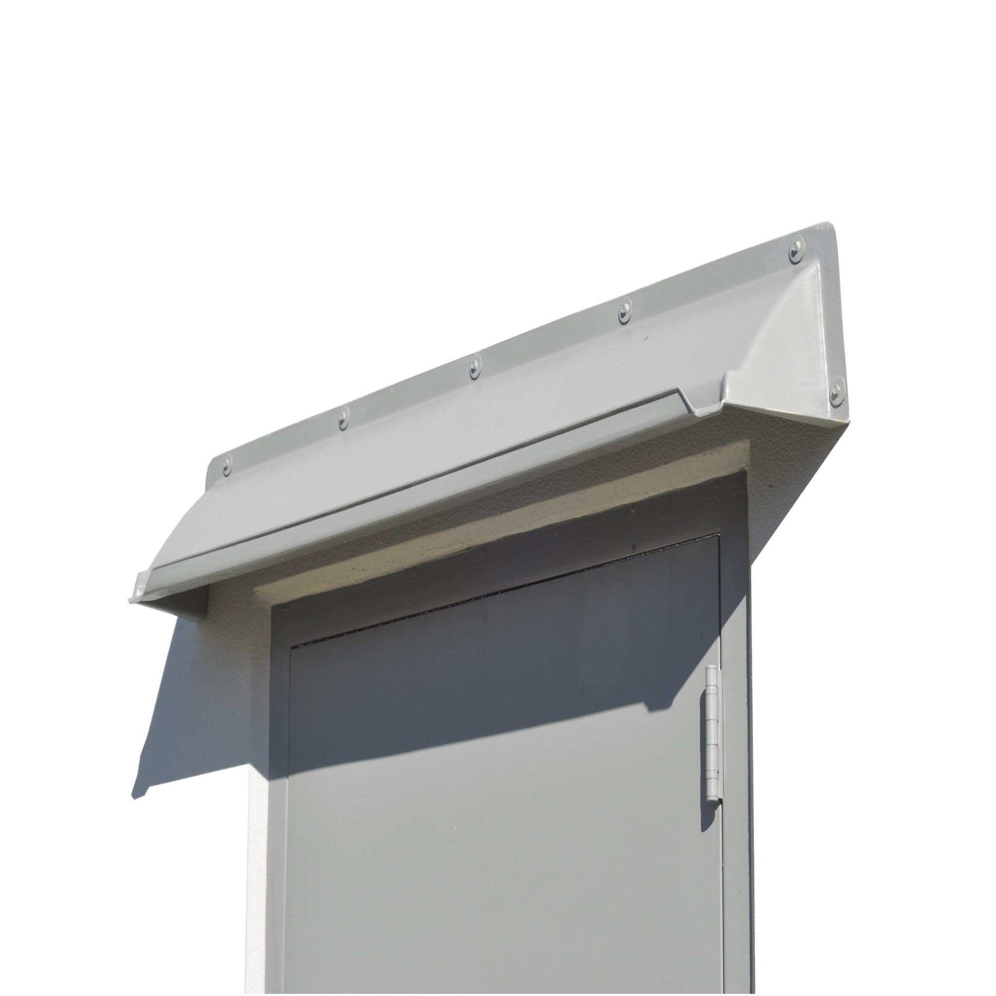 A gray rain diverter mounted above a gray hollow metal door in a white building.