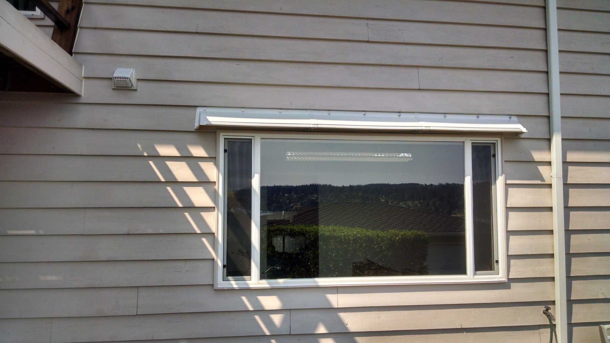 Window with installed Garage Door Rain Diverter to prevent water dripping and fix leaking windows