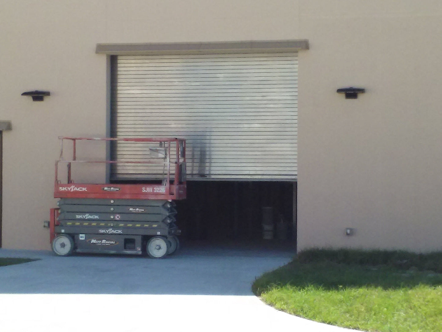 fix leaking windows during heavy rain with a DOORBRIM rain diverter shown above an overhead roll up door.